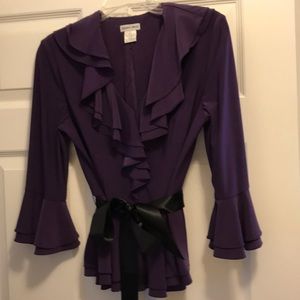 Purple blouse with black tie around waist.